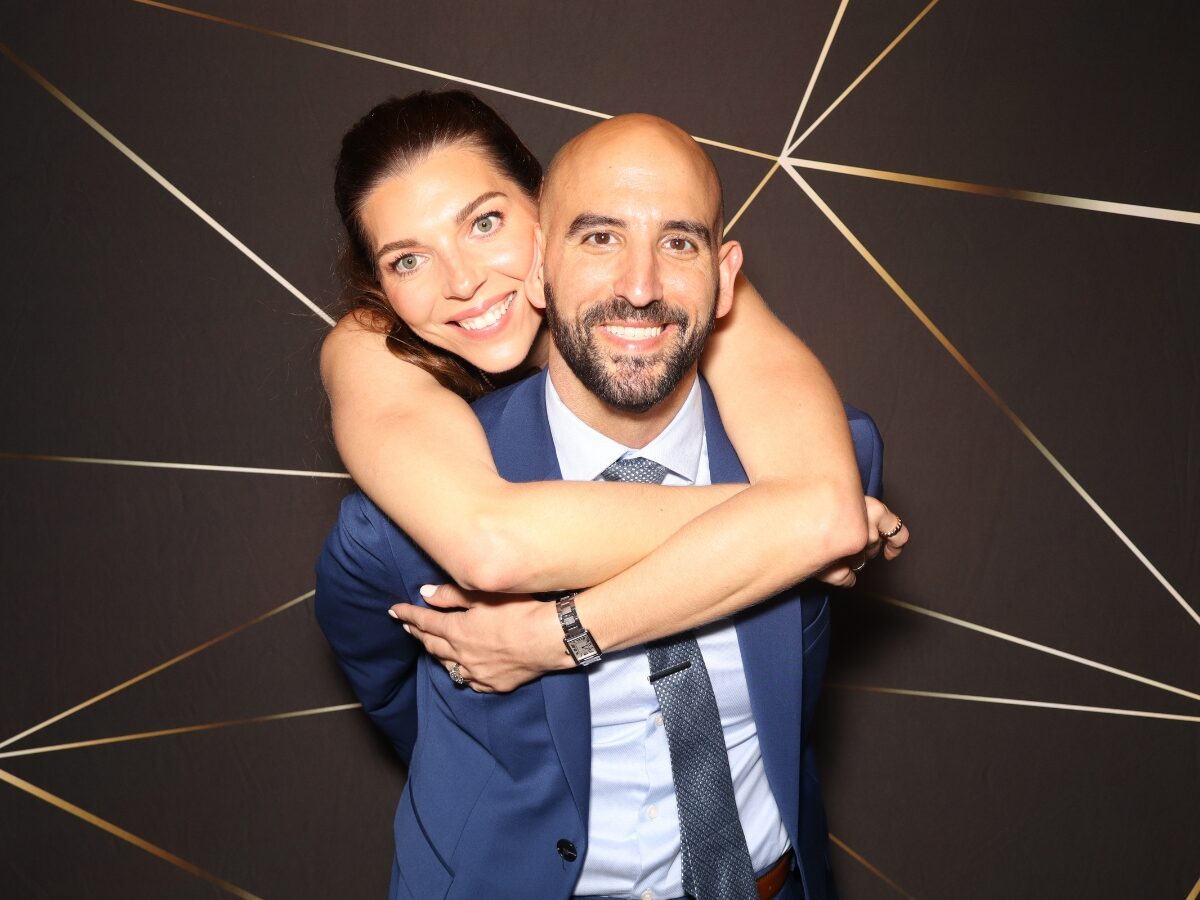 Novios haciendo una pose en la cabina de fotos al aire libre