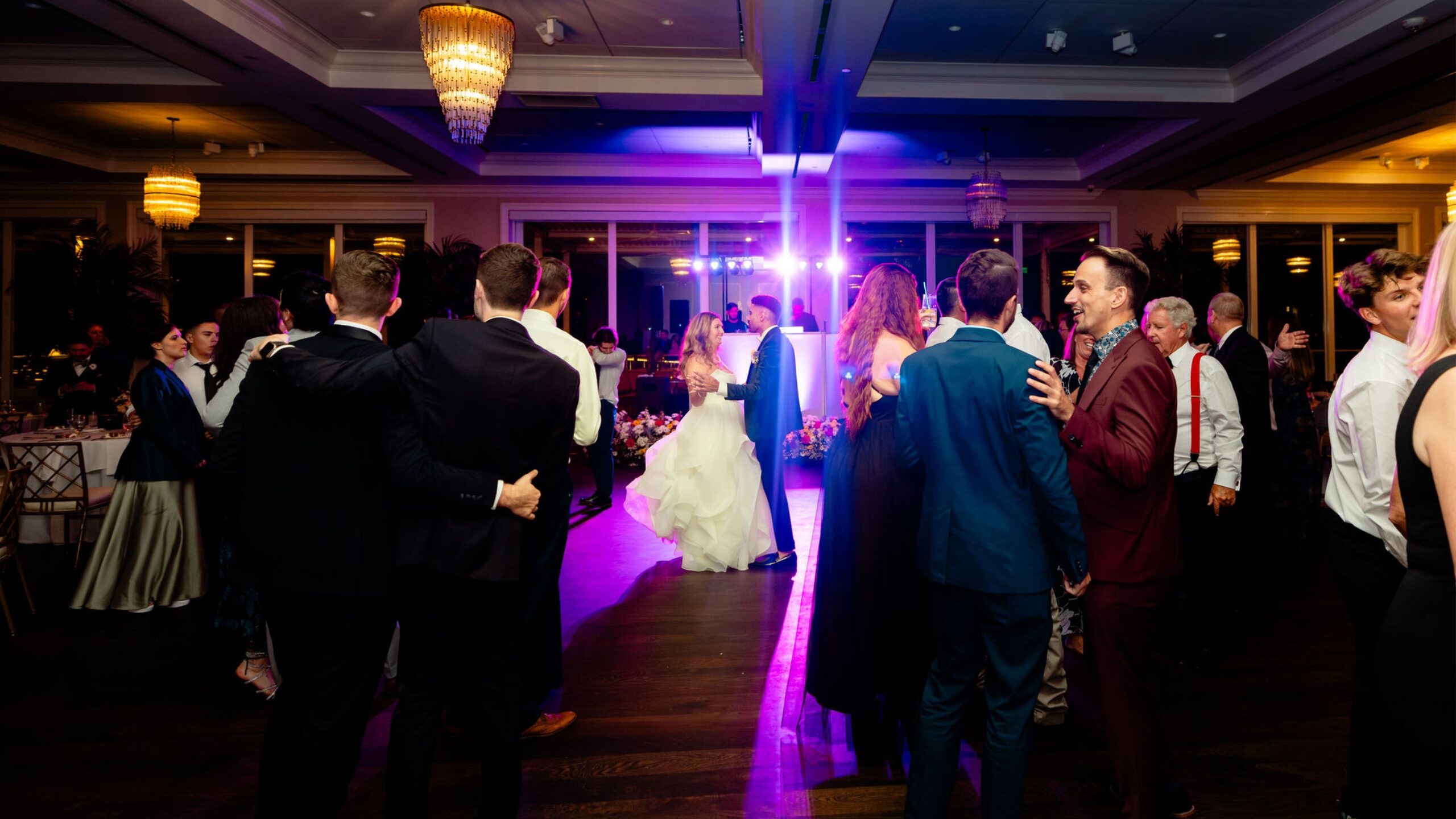 Pista de baile llena mientras los recién casados bailan juntos en el centro en una boda en el sur de Florida