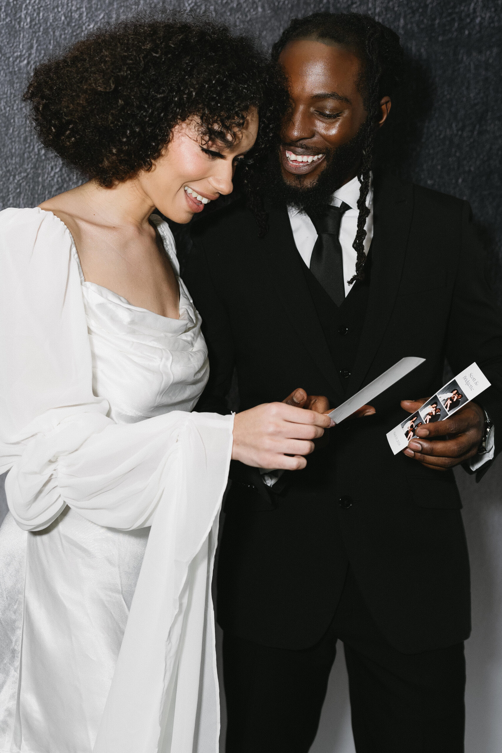 Newlyweds smiling at their freshly printed photo booth photo