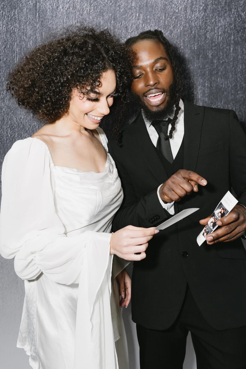 Couple laughing at their fresh photo booth print