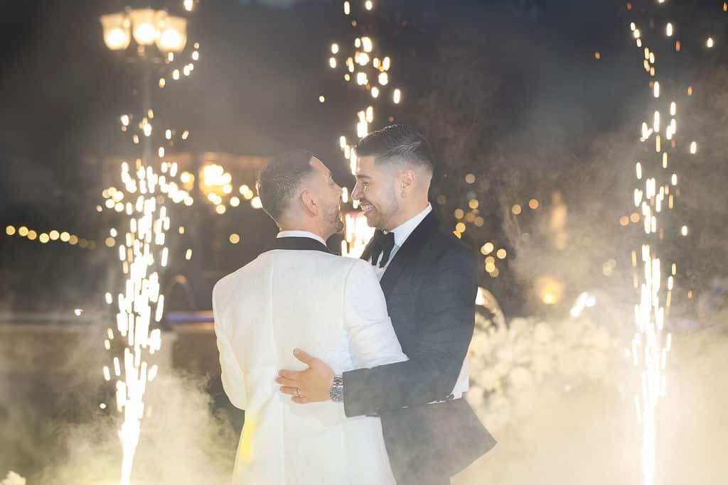 Michael & Andrew sharing a romantic dance surrounded by cold spark fountains and lighting effects at Villa Toscana Miami wedding reception.