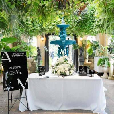 Wedding welcome table with custom signage and floral décor at Villa Toscana Miami wedding venue.